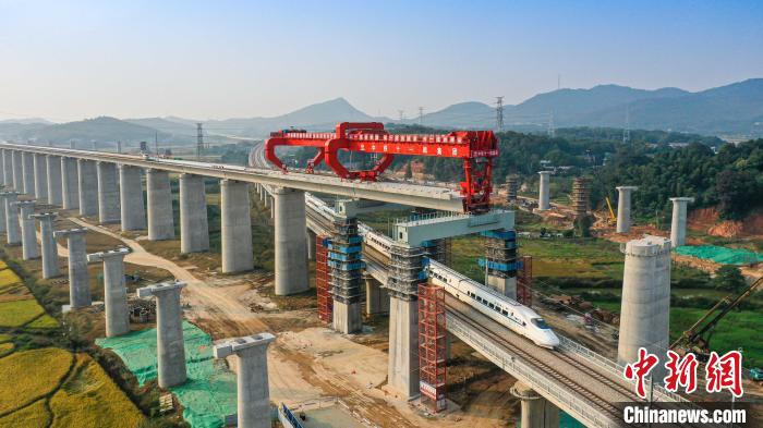 &nbsp;&nbsp;&nbsp;&nbsp;图为乌山联络线动车穿过正在架梁中的常益长高铁黄桥大道特大桥。　彭特　摄