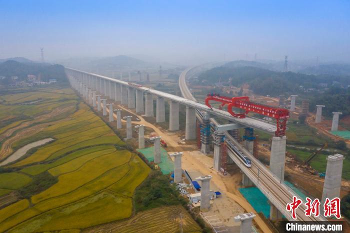 图为乌山联络线动车穿过正在架梁中的常益长高铁黄桥大道特大桥。 彭特 摄