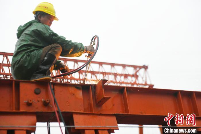 工人冒雨施工。 蒋雪林 摄 工人冒雨施工。 蒋雪林 摄