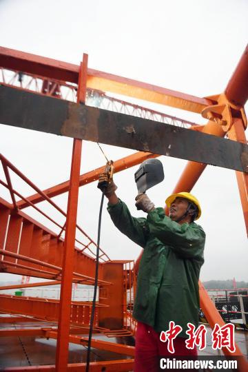 工人冒雨施工。 蒋雪林 摄 工人冒雨施工。 蒋雪林 摄